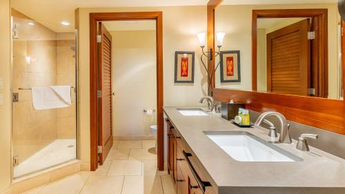 Un baño con dos lavabos y una ducha. en Ko Olina Beach Villas B102, en Kapolei