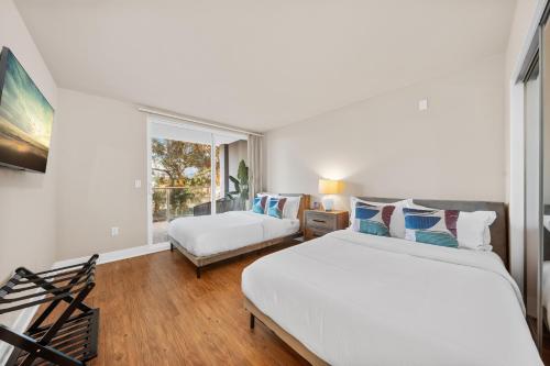 Un dormitorio con dos camas y una ventana. en Azure Marina Luxe - Waterfront with Sunset Views, en Los Ángeles