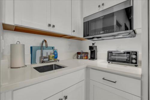 a white kitchen with a sink and a microwave at Peaceful Guest Casita with Private Entrance and No Cleaning Fee in Hanford
