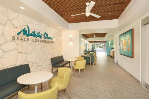 a restaurant with tables and chairs and a stone wall at Waikiki Shore by OUTRIGGER in Honolulu