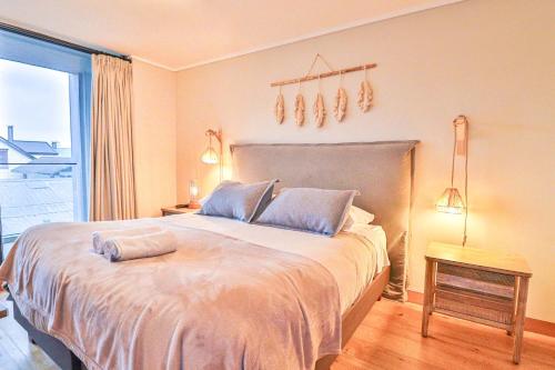 a bedroom with a large bed with a window at HOM I 2D2B Conjunto frente a la Costanera in Puerto Varas