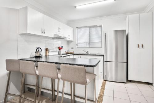 a kitchen with white cabinets and a stainless steel refrigerator at 1-68 Woodburn Street in Evans Head