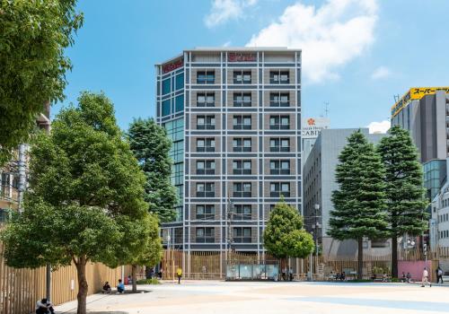 a tall building with trees in front of it at La'gent Hotel Shinjuku Kabukicho in Tokyo