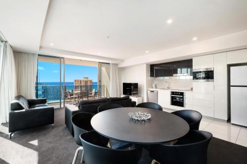 a kitchen and living room with a table and chairs at Number 1 H Residences - WiFi, Parking & More by Gold Coast Holidays in Gold Coast