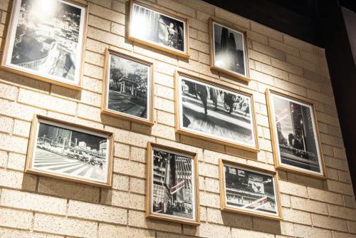 a wall of pictures on a brick wall at La'gent Hotel Shinjuku Kabukicho in Tokyo