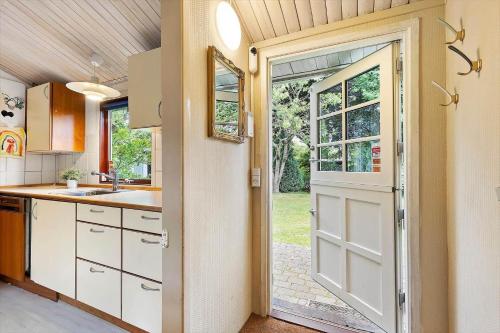 a kitchen with a door leading to a yard at FJ1200-Jaegerspris-Planetvej-8 in Jægerspris