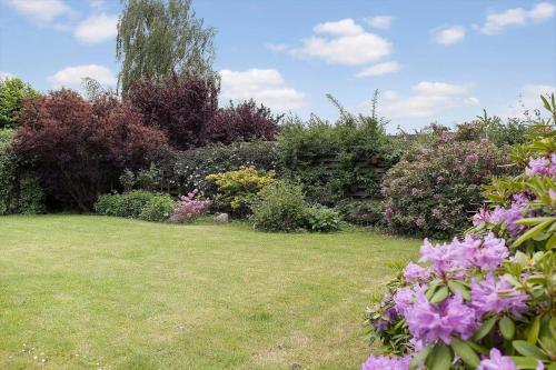 a garden with pink flowers in the grass at FJ1200-Jaegerspris-Planetvej-8 in Jægerspris