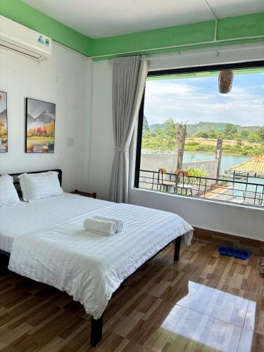 a bedroom with a bed and a large window at Horizon Homestay in Phong Nha
