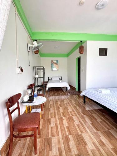 a room with two beds and a table and chairs at Horizon Homestay in Phong Nha
