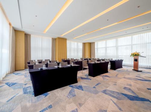 a large room with a row of tables and chairs at Novotel Xiamen Downtown in Xiamen