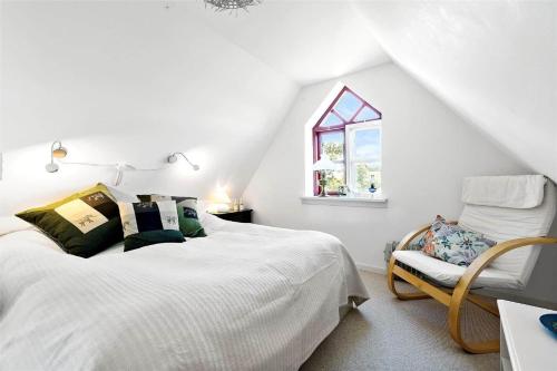 a white bedroom with a bed and a chair at 8008-Knebel-Sletterhagevej-2 in Knebel