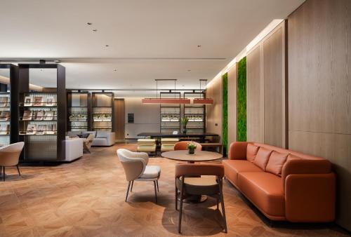 a lobby with a couch and a table and chairs at Novotel Xiamen Downtown in Xiamen
