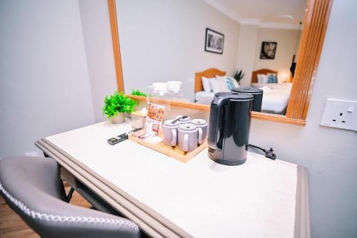 a coffee maker on a table in front of a mirror at Kingston Hotel 11 - PWTC, KL in Kuala Lumpur