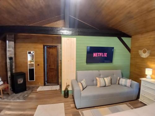 a couch in a living room with a sign on the wall at Popa Cabana in Sibiu
