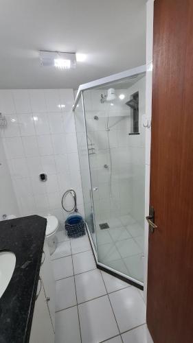 a bathroom with a shower and a sink and a toilet at Prainha Arraial do Cabo Loft in Arraial do Cabo