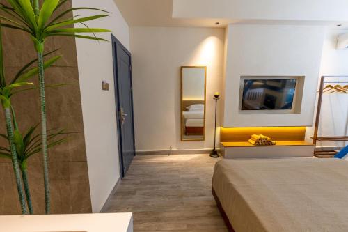 a hotel room with a bed and a plant at 云隐兮江景民宿 in Fenghuang