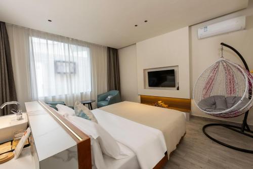 a hotel room with a bed and a hanging chair at 云隐兮江景民宿 in Fenghuang