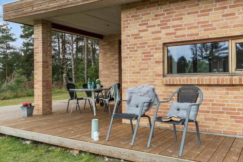 a patio with chairs and a table on a deck at 84114-Ebeltoft-Laerkevej-13-A in Ebeltoft