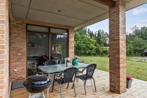 a patio with a table and chairs on a deck at 84114-Ebeltoft-Laerkevej-13-A in Ebeltoft