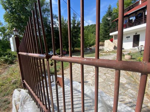 a gate in a fence with a building in the background at To σαλέ της λίμνης 2 in Kalyvia Fylaktis