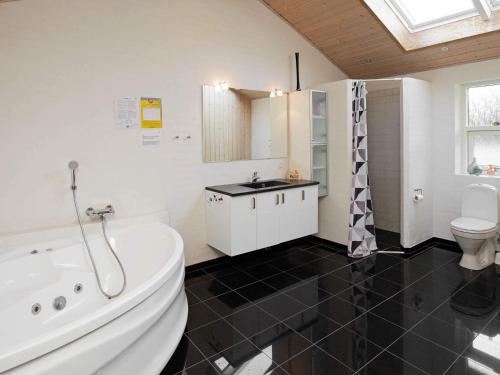 a bathroom with a tub and a sink and a toilet at Luxury Retreat in Bratten - By Traum Ferienwohnungen in Jerup