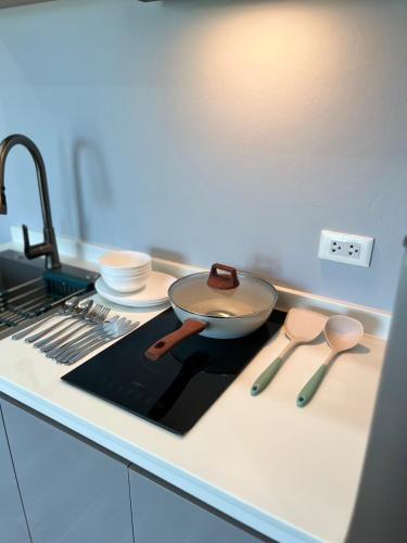 a kitchen counter with a frying pan and utensils at UPMOON Hotel in Ban Suan