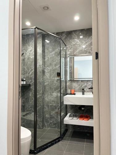 a bathroom with a shower and a sink at UPMOON Hotel in Ban Suan