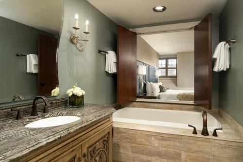 a bathroom with a tub and a sink and a mirror at Grand Bohemian Lodge Asheville, Autograph Collection in Asheville