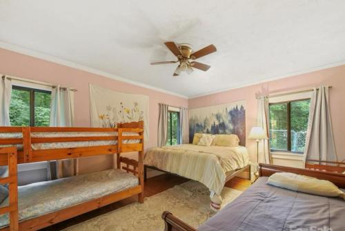 a bedroom with two beds and a ceiling fan at Mountain Cottage on 7 Acres in Tryon