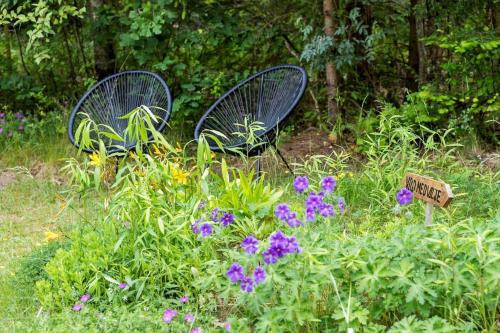 two chairs sitting in a garden with purple flowers at 84127-Ebeltoft-Magevej-19 in Ebeltoft