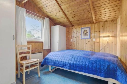 a bedroom with a bed and a chair and a window at 8116-Ega-Under-Ronnene-37 in Egå