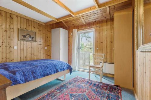 a bedroom with a bed and a window and a chair at 8116-Ega-Under-Ronnene-37 in Egå
