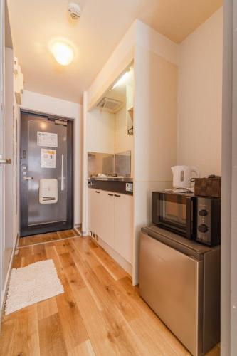 a kitchen with a microwave on a counter in a room at Wajiro Good Place House in Fukuoka