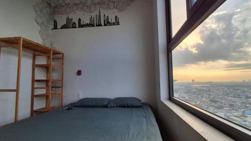 a bedroom with a bed and a large window at Bcons Garden Luxury Aparment in Dĩ An