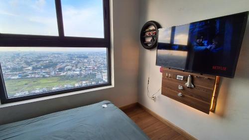 a bedroom with a flat screen tv on a wall at Bcons Garden Luxury Aparment in Dĩ An