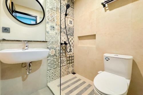 a bathroom with a toilet and a sink and a mirror at SANS Siliwangi Semarang in Kalibanteng-kidul
