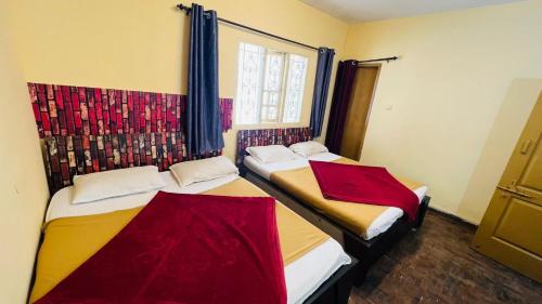 two beds in a room with a window at Hidden doors apartment in Ooty