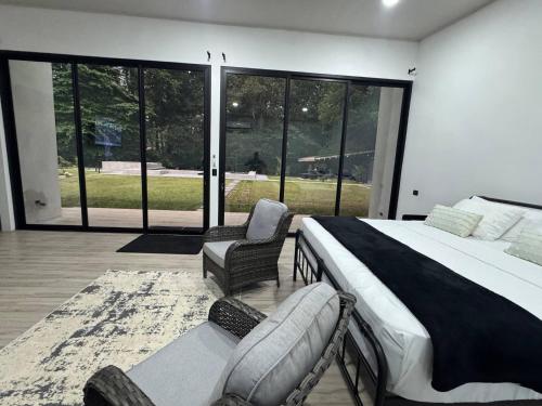 ein Schlafzimmer mit einem großen Bett und zwei Stühlen in der Unterkunft Seven Paradise - Your personal rainforest in Fortuna