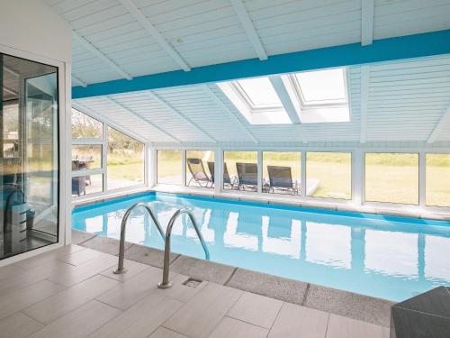 a swimming pool in a house with a large window at 8 person holiday home in Løkken in Løkken