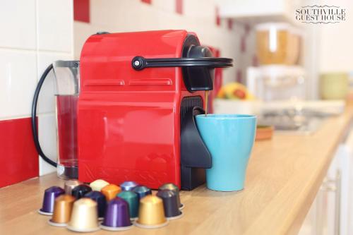 a red coffee maker sitting on a counter next to a cup at Southville Guest House in Bristol