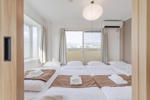 a bedroom with two beds and a window at Ijiri Good Place House in Fukuoka