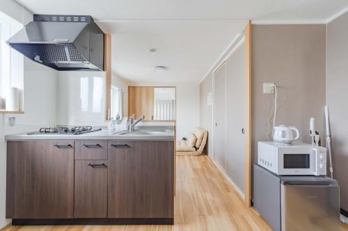 a kitchen with a sink and a microwave at Ijiri Good Place House in Fukuoka