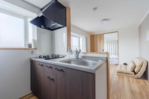 a kitchen with a sink and a large window at Ijiri Good Place House in Fukuoka
