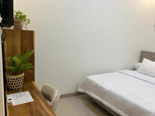 a bedroom with a bed and a table with a chair at D'illy Borobudur Villa in Magelang