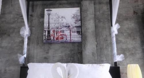 a bedroom with a bed with a picture of a red bike at The Key Hotel in Ko Lipe
