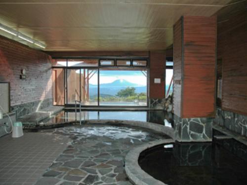 a bathroom with a tub with a view of a mountain at Kirishima Onsen Ryokojin Sanso in Kirishima
