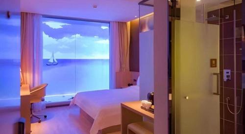 a room with a bedroom with a view of the ocean at IU Hotel Baoding Goverment Shidai in Baoding
