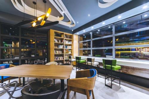a dining room with a wooden table and chairs at Shanghai Zeyu Hotel in Shanghai