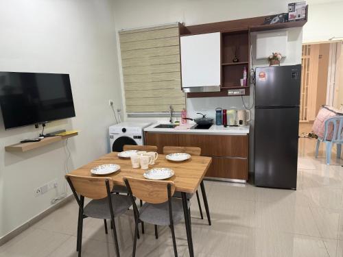 une cuisine avec une table avec des chaises et un réfrigérateur dans l'établissement Nilai Rooftop skywalk at mesahill premier by STAY COZY, à Nilai