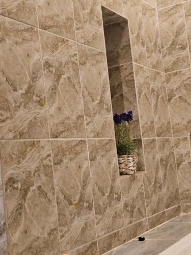 a bathroom with a stone shower with a mirror at Home RÉSIDENCE OUIDAH in Ouidah
